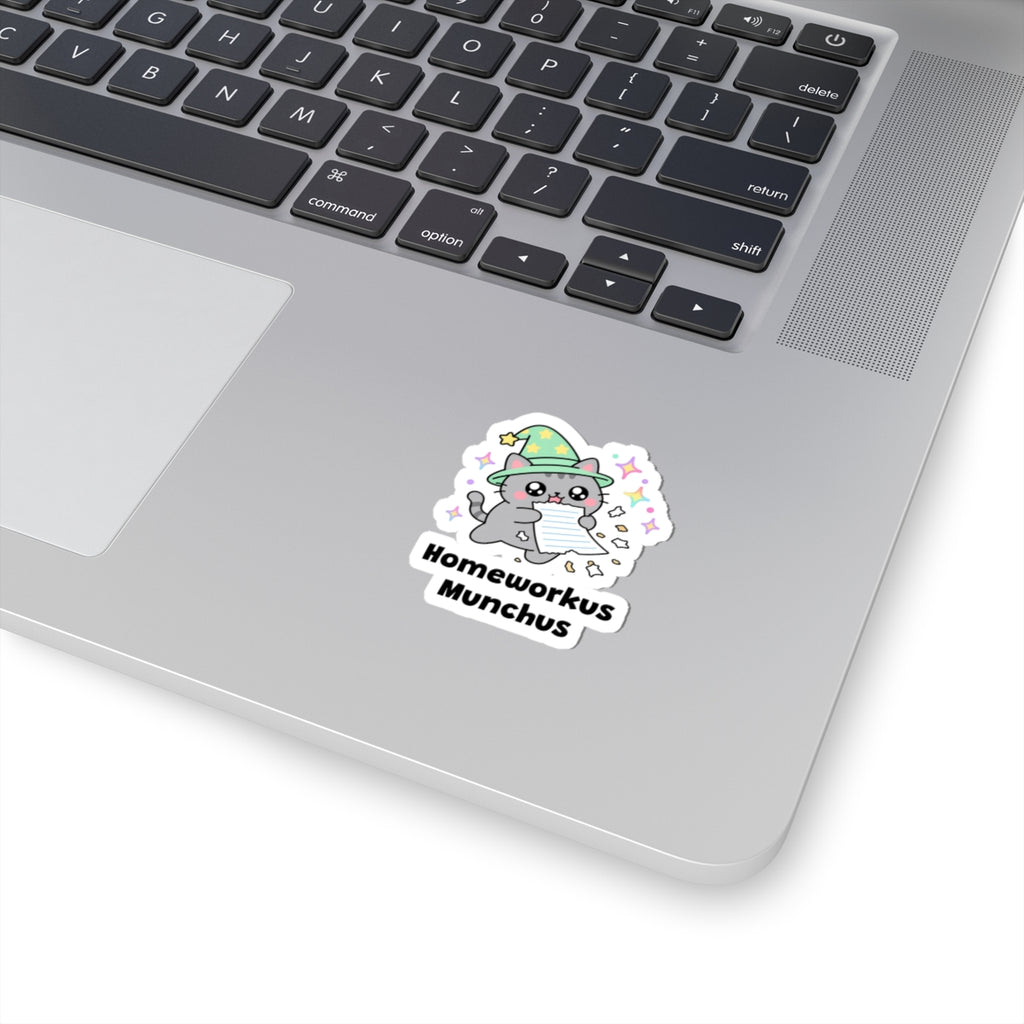Homeworkus Munchus wizard cat sticker stuck on a silver laptop next to the keyboard