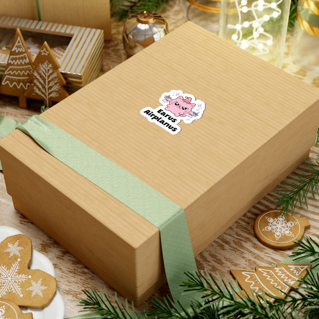 Earus Airplanus wizard cat sticker on a kraft gift box with a green ribbon and holiday cookies