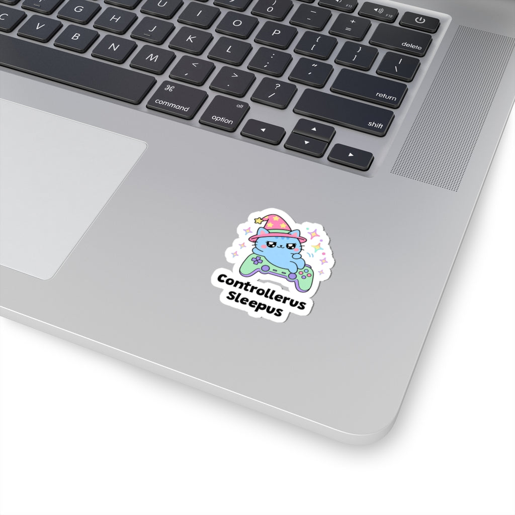 Controllerus Sleepus wizard cat sticker stuck on a silver laptop next to the keyboard