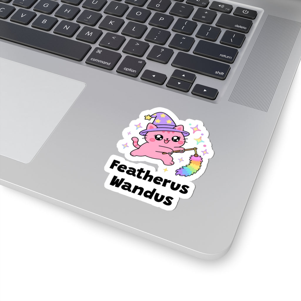 Featherus Wandus wizard cat sticker stuck on a silver laptop next to the keyboard