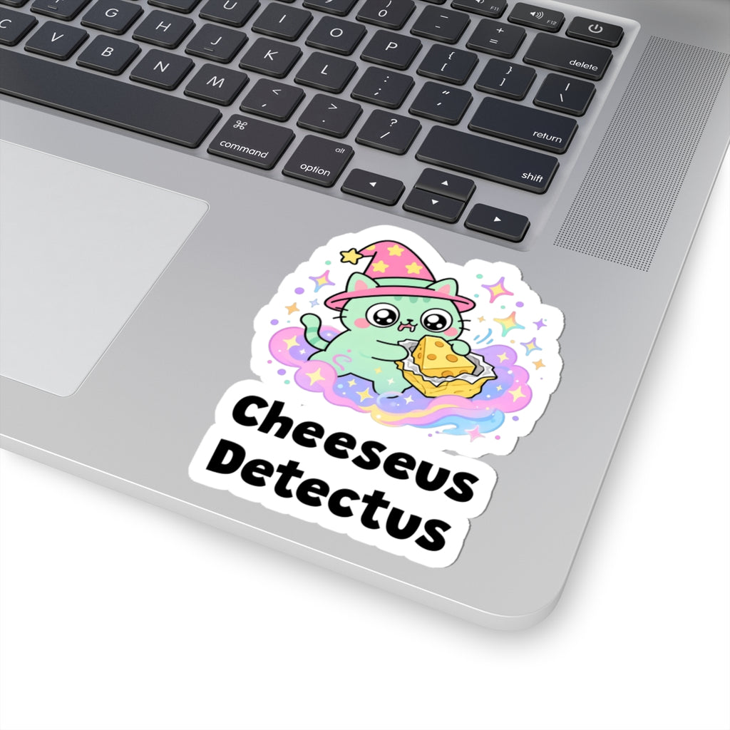 Cheeseus Detectus wizard cat sticker stuck on a silver laptop next to the keyboard