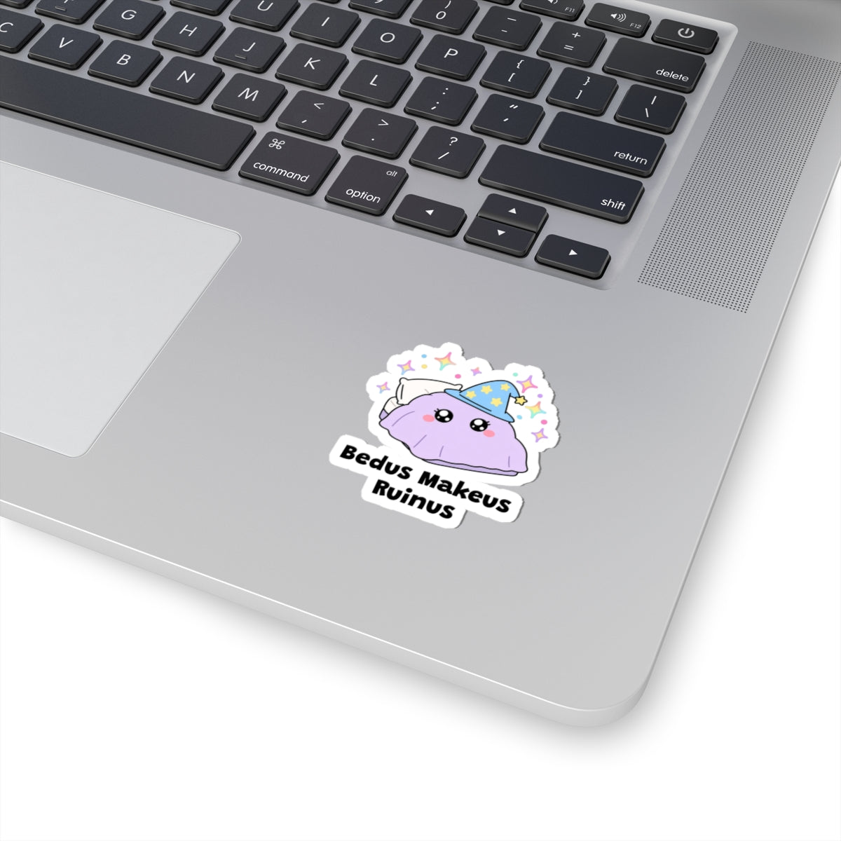 Bedus Makeus Ruinus wizard cat sticker stuck on a silver laptop next to the keyboard