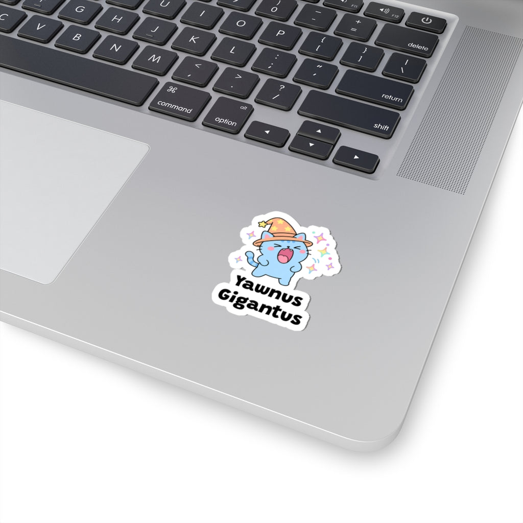 Yawnus Gigantus wizard cat sticker stuck on a silver laptop next to the keyboard