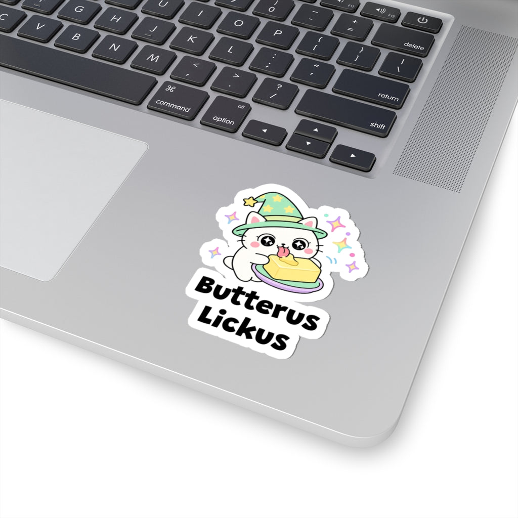 Butterus Lickus wizard cat sticker stuck on a silver laptop next to the keyboard