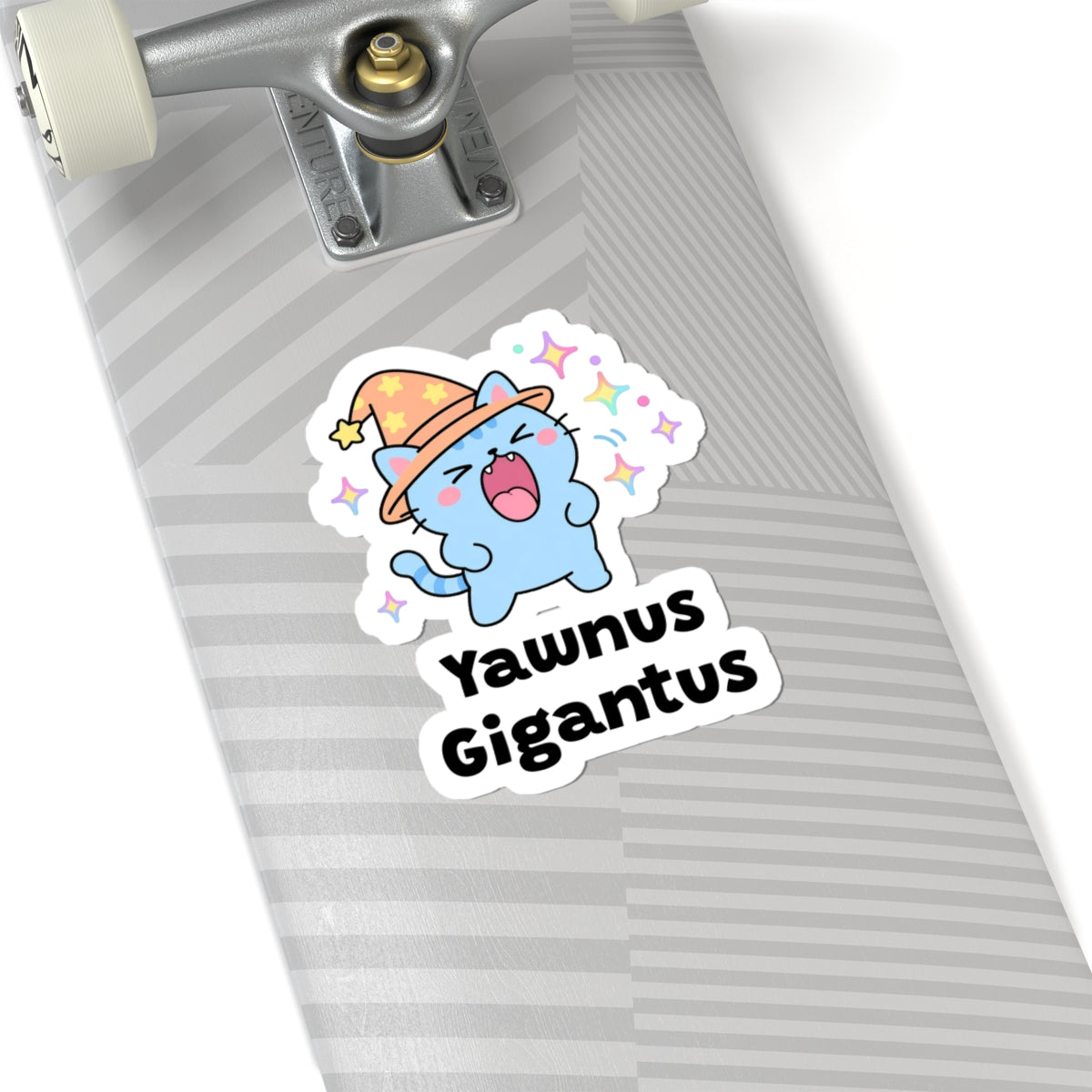 Yawnus Gigantus wizard cat sticker on a grey skateboard deck near the truck