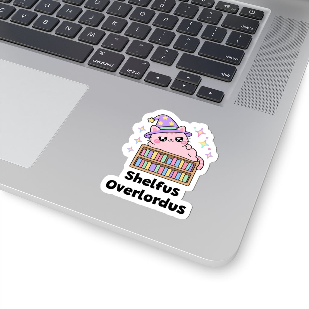 Shelfus Overlordus wizard cat sticker stuck on a silver laptop next to the keyboard