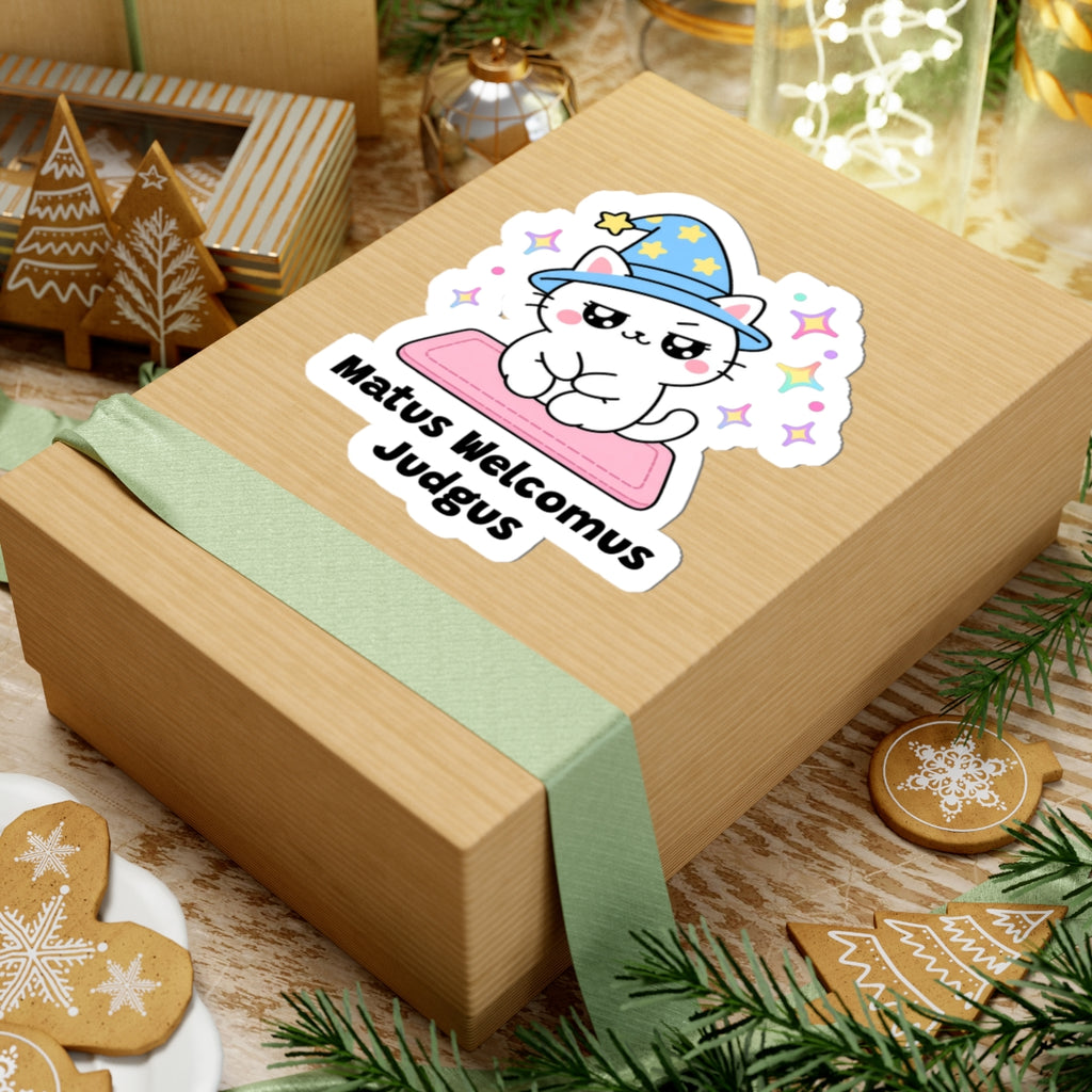 Matus Welcomus Judgus wizard cat sticker on a kraft gift box with a green ribbon and holiday cookies
