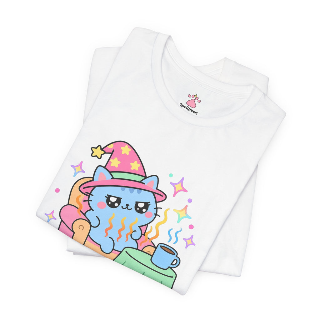 Folded white Chairus Warmus Stealus T-shirt showing a close-up of the blue wizard cat in a pink hat lounging in a warm orange armchair beside a coffee mug