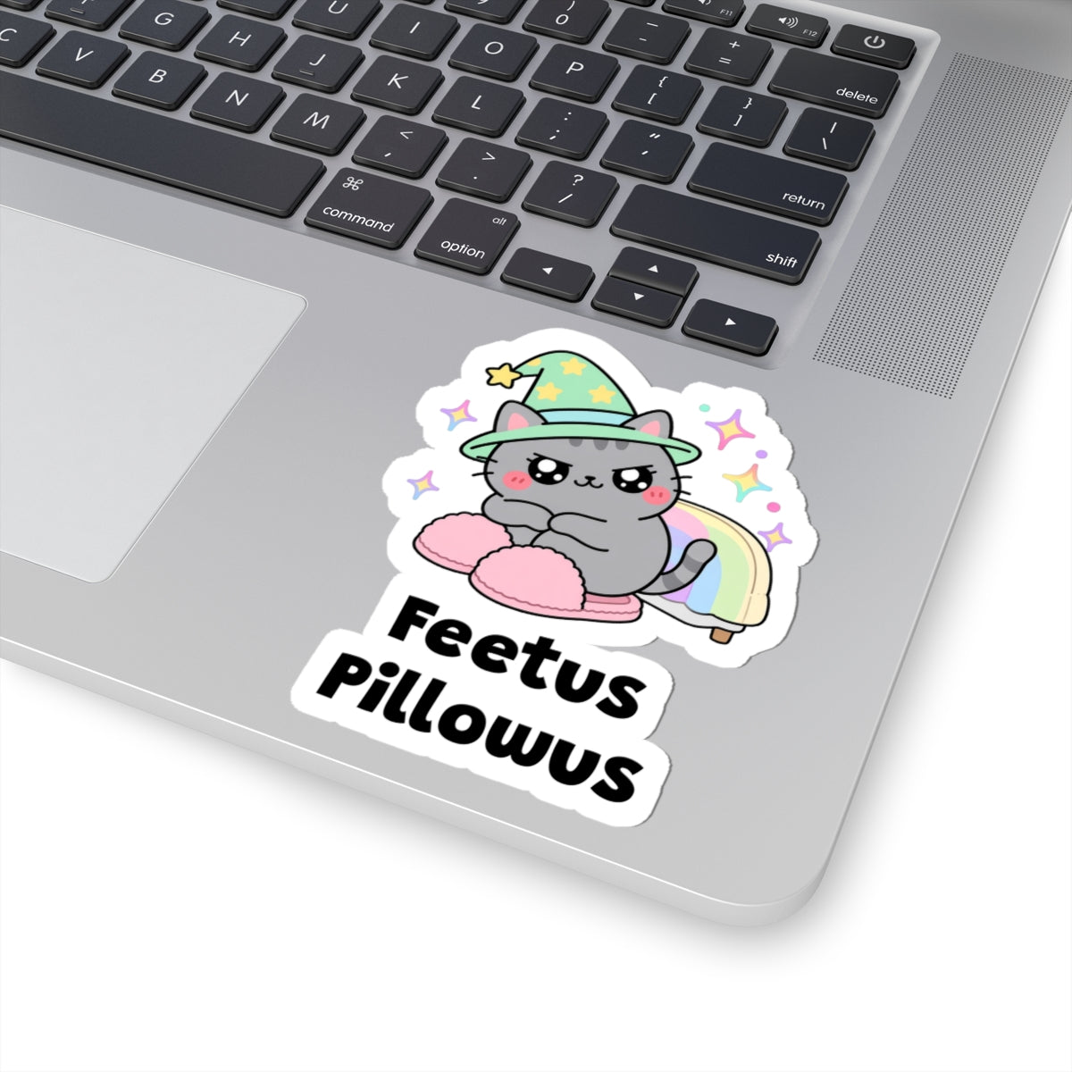 Feetus Pillowus wizard cat sticker stuck on a silver laptop next to the keyboard