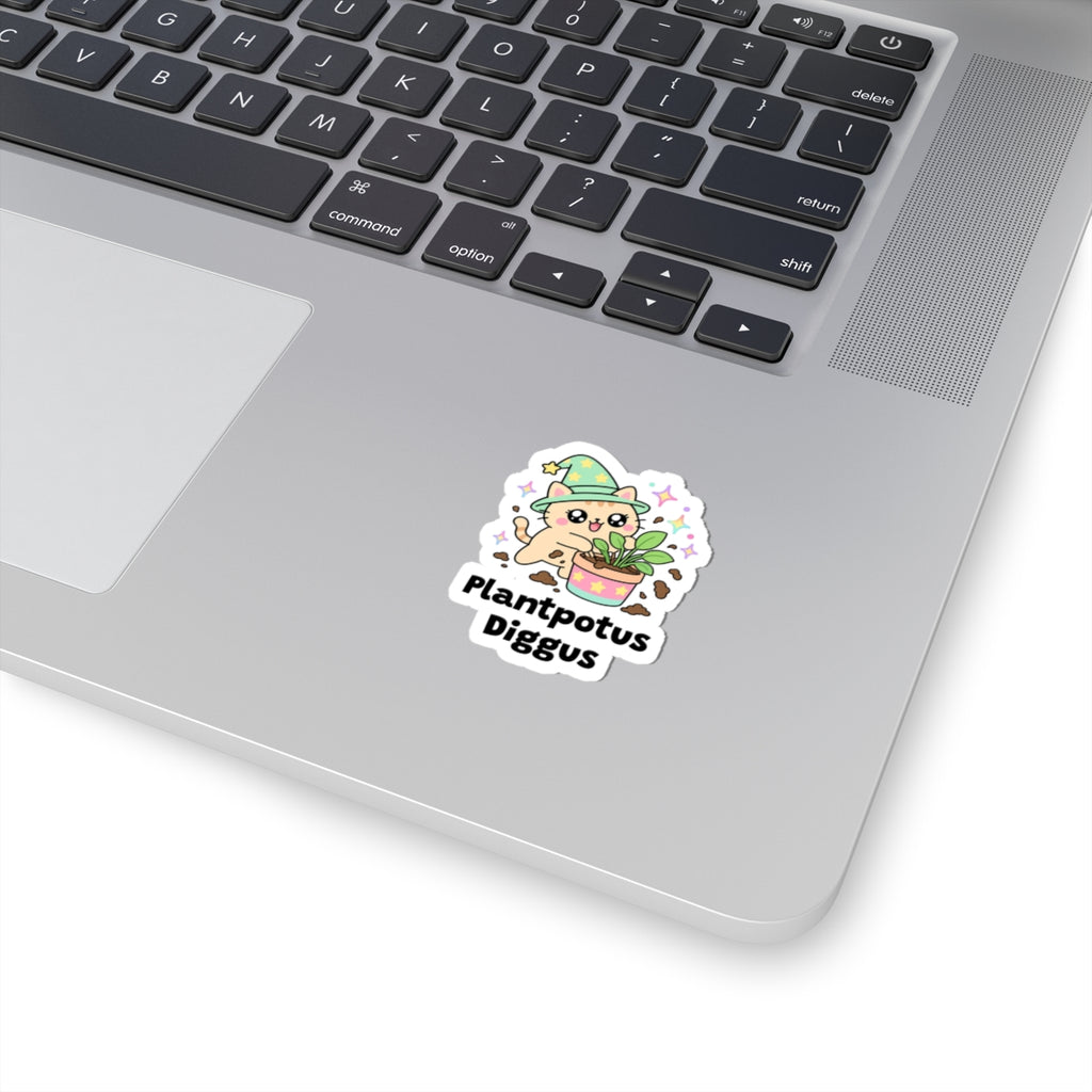 Plantpotus Diggus wizard cat sticker stuck on a silver laptop next to the keyboard