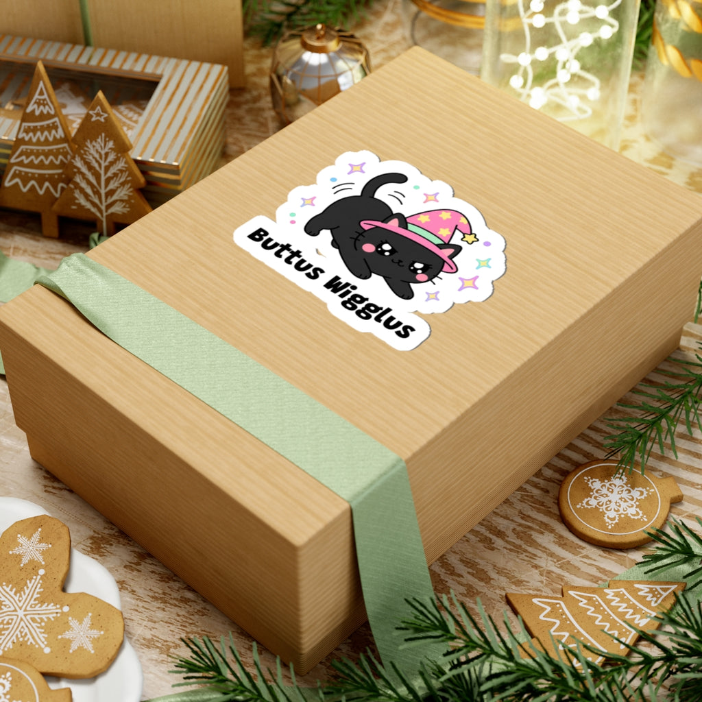 Buttus Wigglus wizard cat sticker on a kraft gift box with a green ribbon and holiday cookies