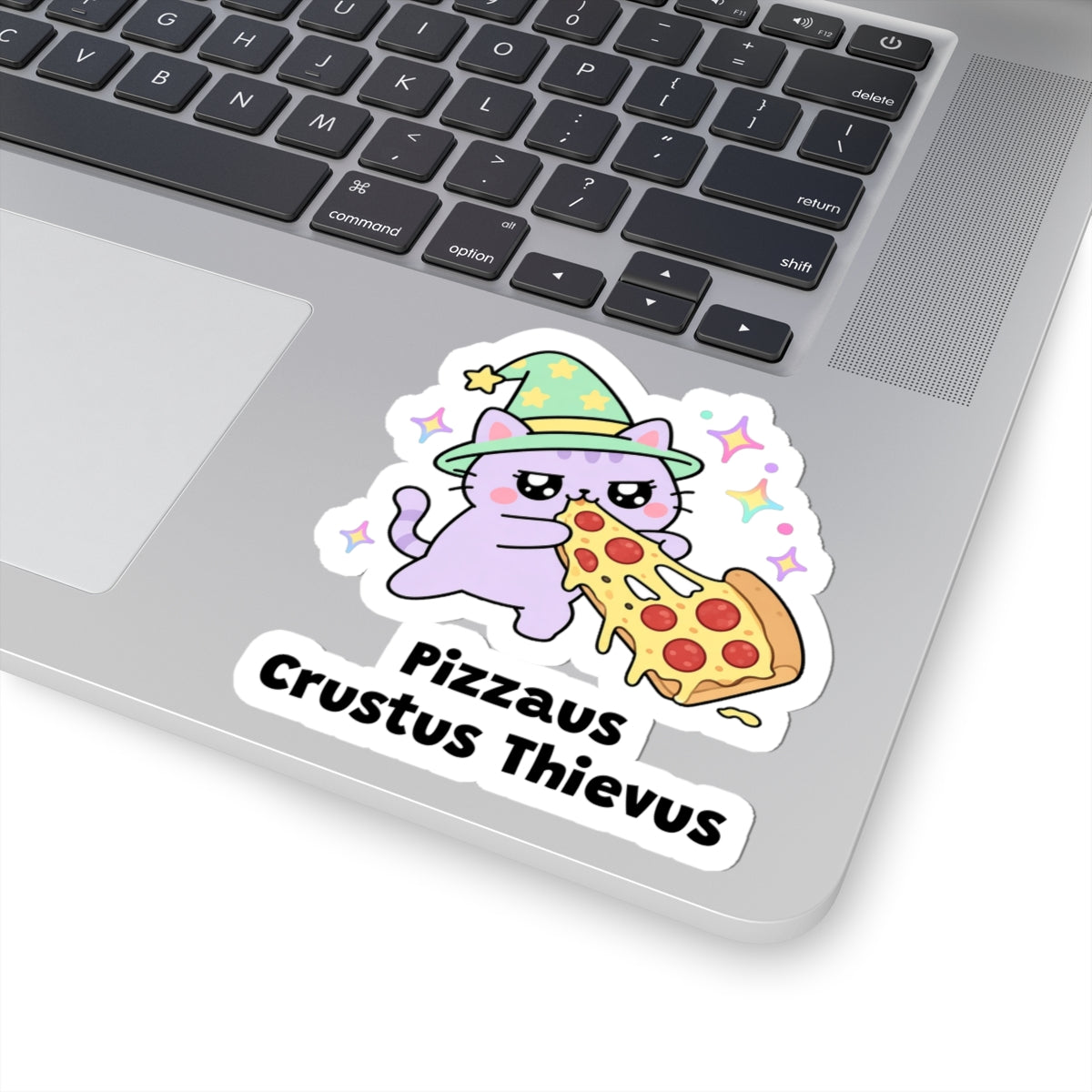 Pizzaus Crustus Thievus wizard cat sticker stuck on a silver laptop next to the keyboard