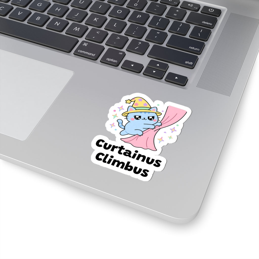 Curtainus Climbus wizard cat sticker stuck on a silver laptop next to the keyboard