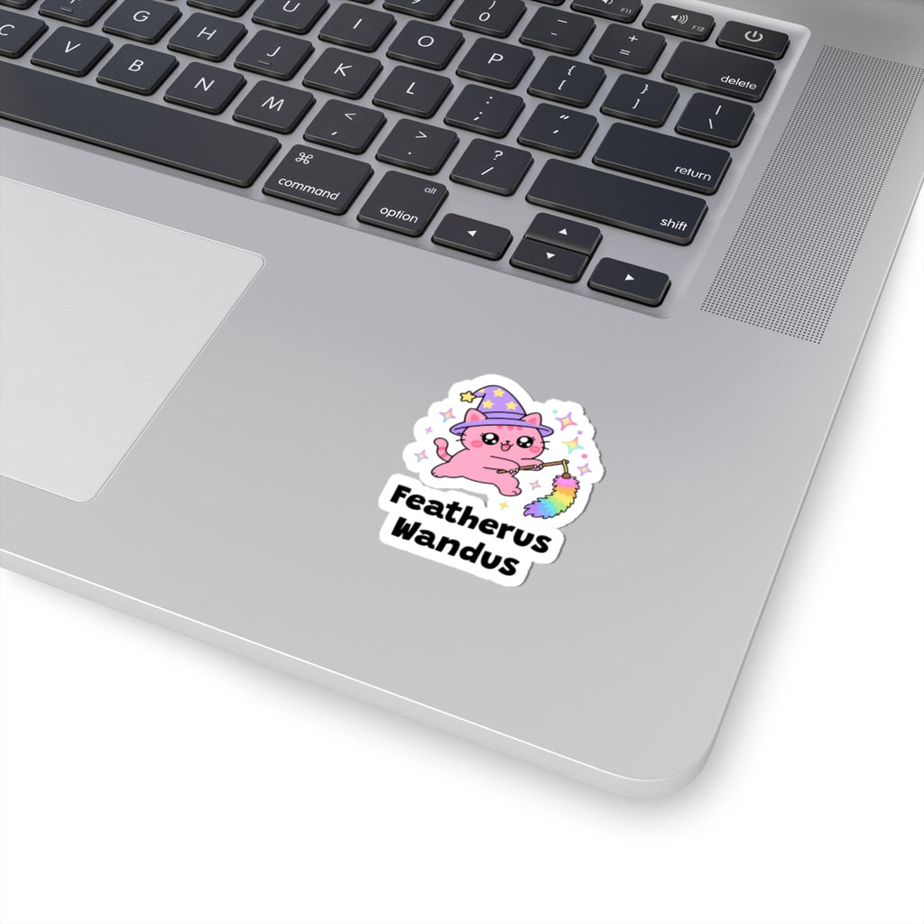 Featherus Wandus wizard cat sticker stuck on a silver laptop next to the keyboard