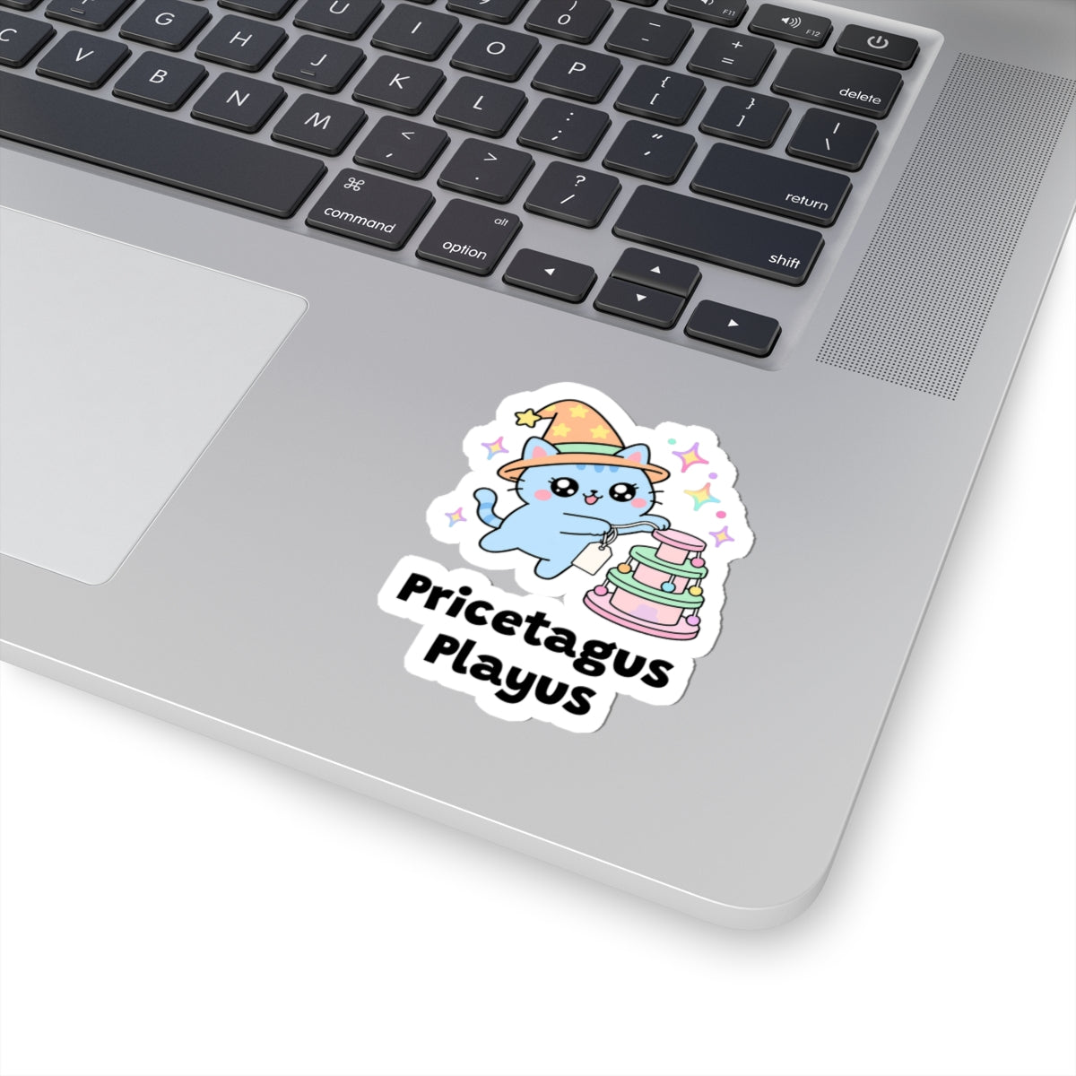 Pricetagus Playus wizard cat sticker stuck on a silver laptop next to the keyboard