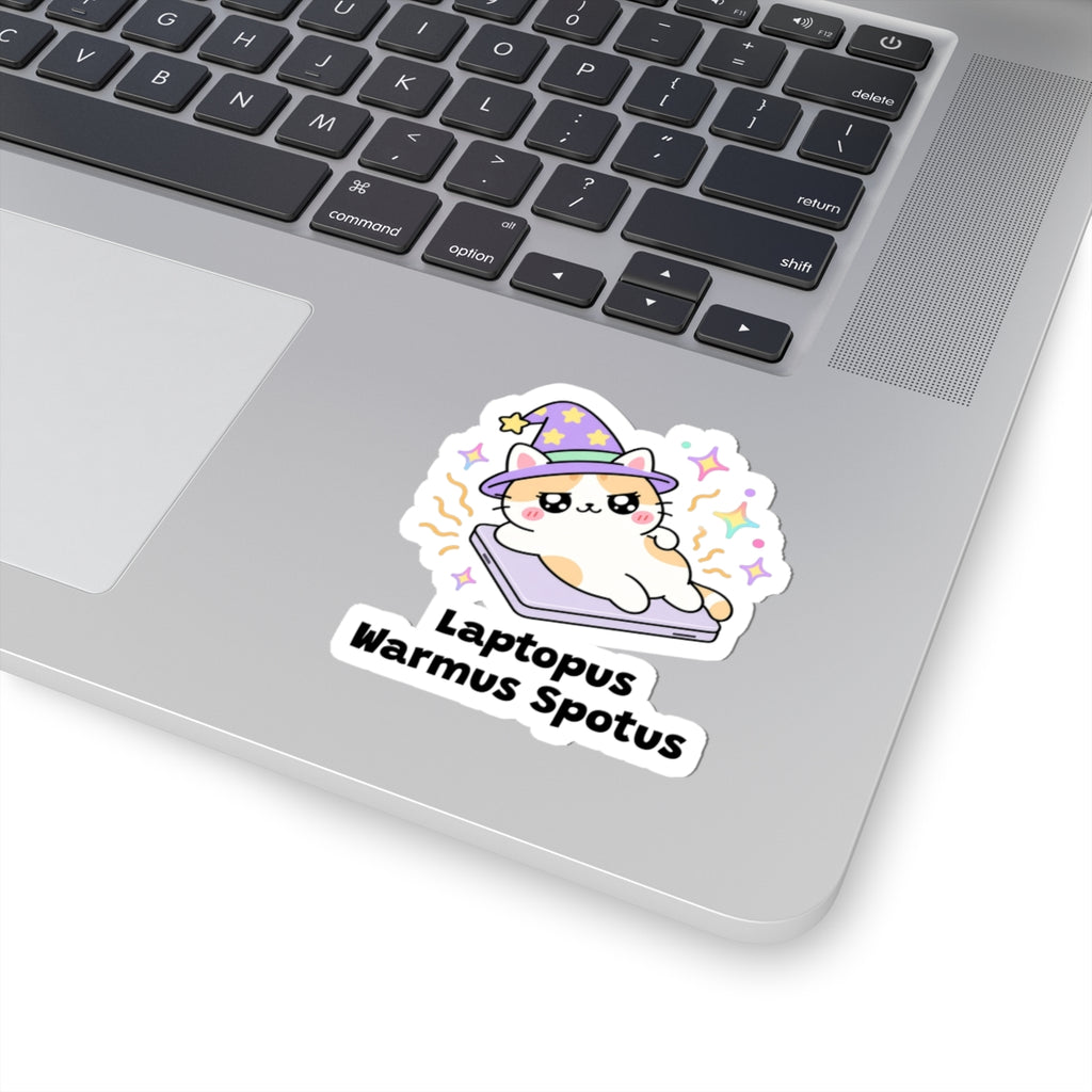 Laptopus Warmus Spotus wizard cat sticker stuck on a silver laptop next to the keyboard