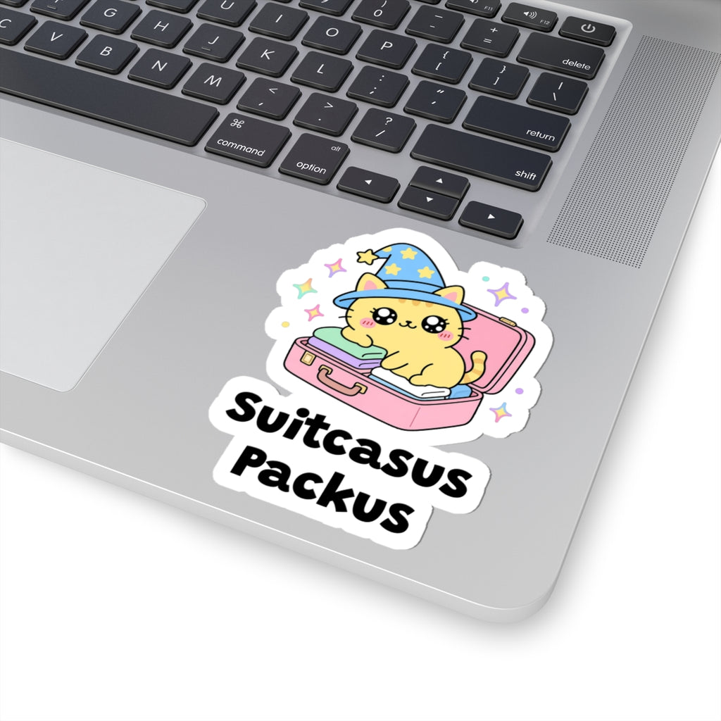 Suitcasus Packus wizard cat sticker stuck on a silver laptop next to the keyboard