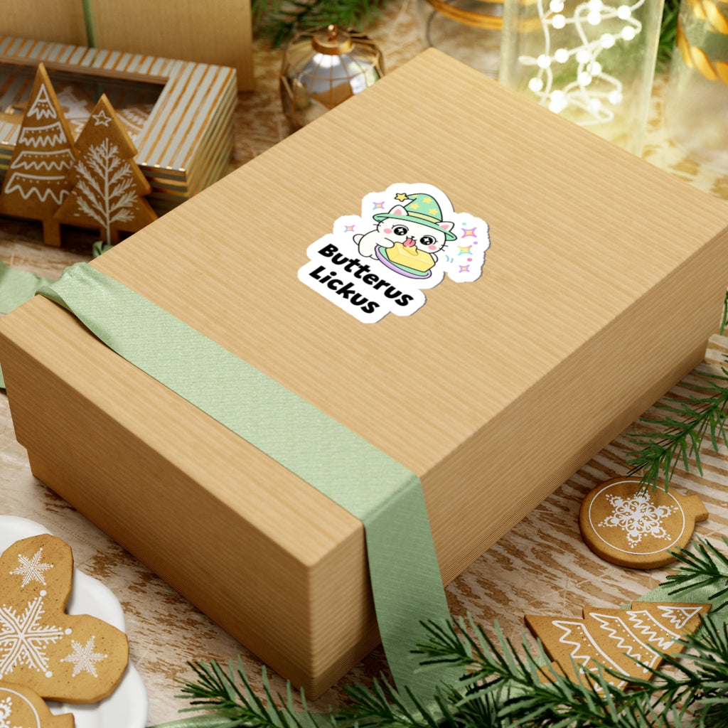 Butterus Lickus wizard cat sticker on a kraft gift box with a green ribbon and holiday cookies