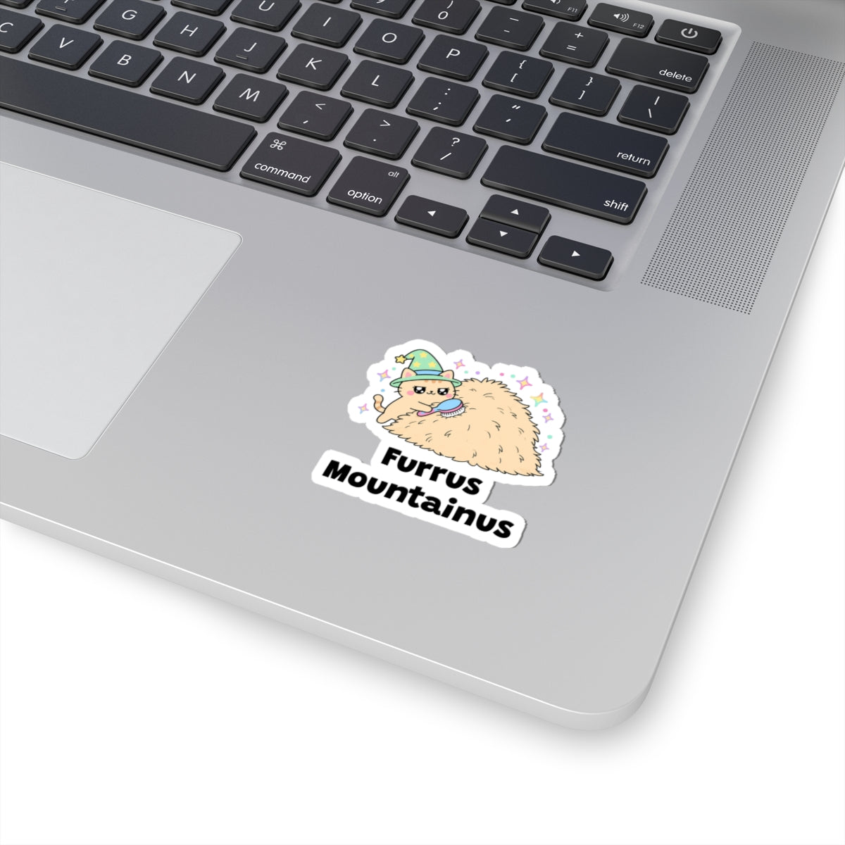 Furrus Mountainus wizard cat sticker stuck on a silver laptop next to the keyboard