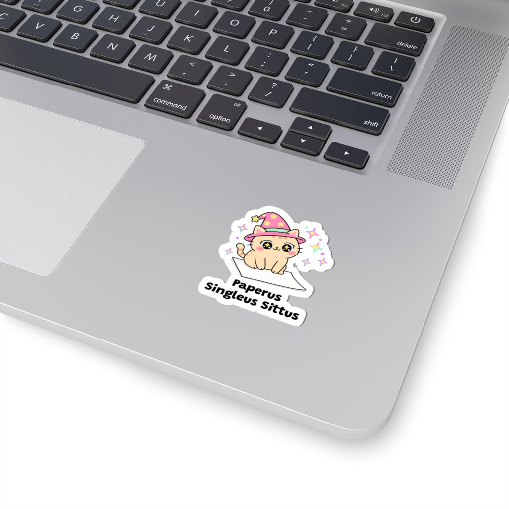Paperus Singleus Sittus wizard cat sticker stuck on a silver laptop next to the keyboard