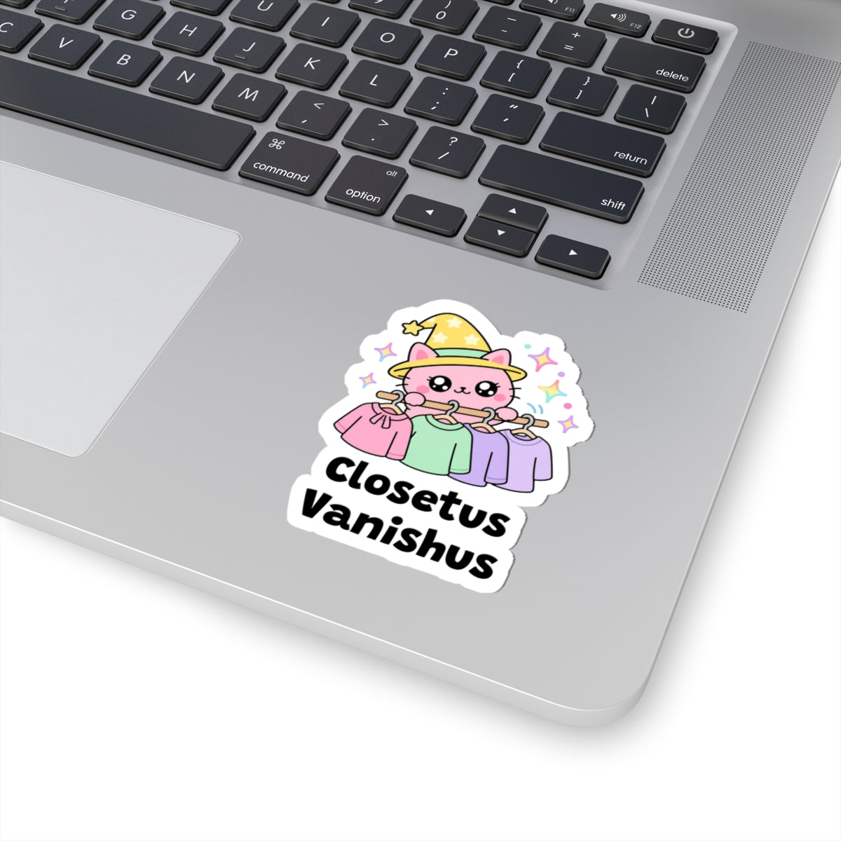 Closetus Vanishus wizard cat sticker stuck on a silver laptop next to the keyboard