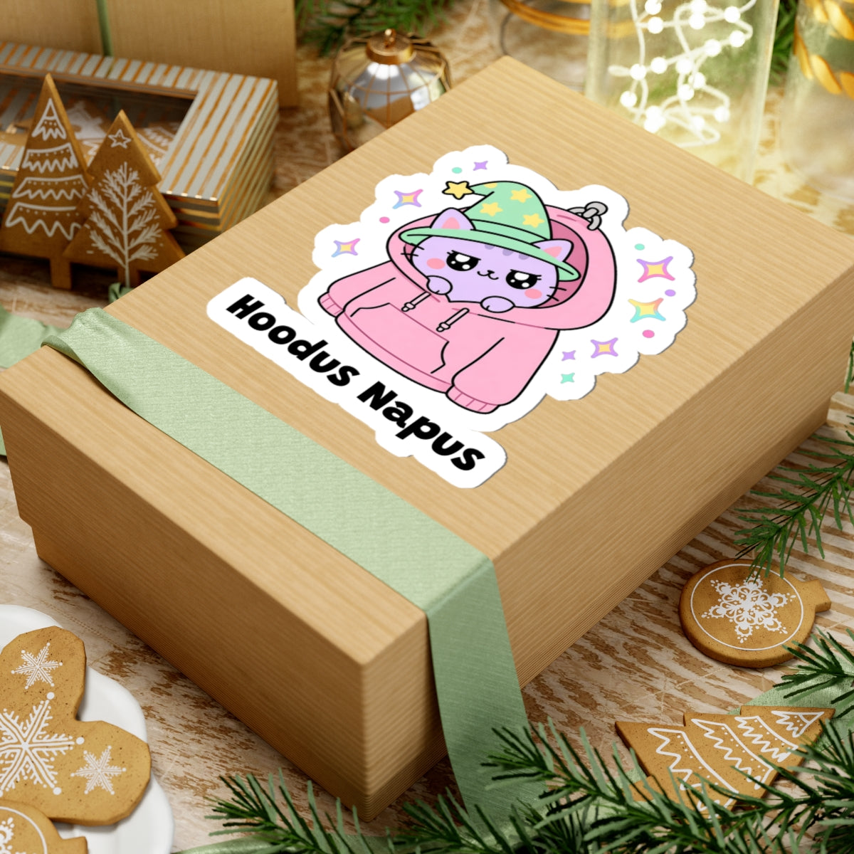 Hoodus Napus wizard cat sticker on a kraft gift box with a green ribbon and holiday cookies