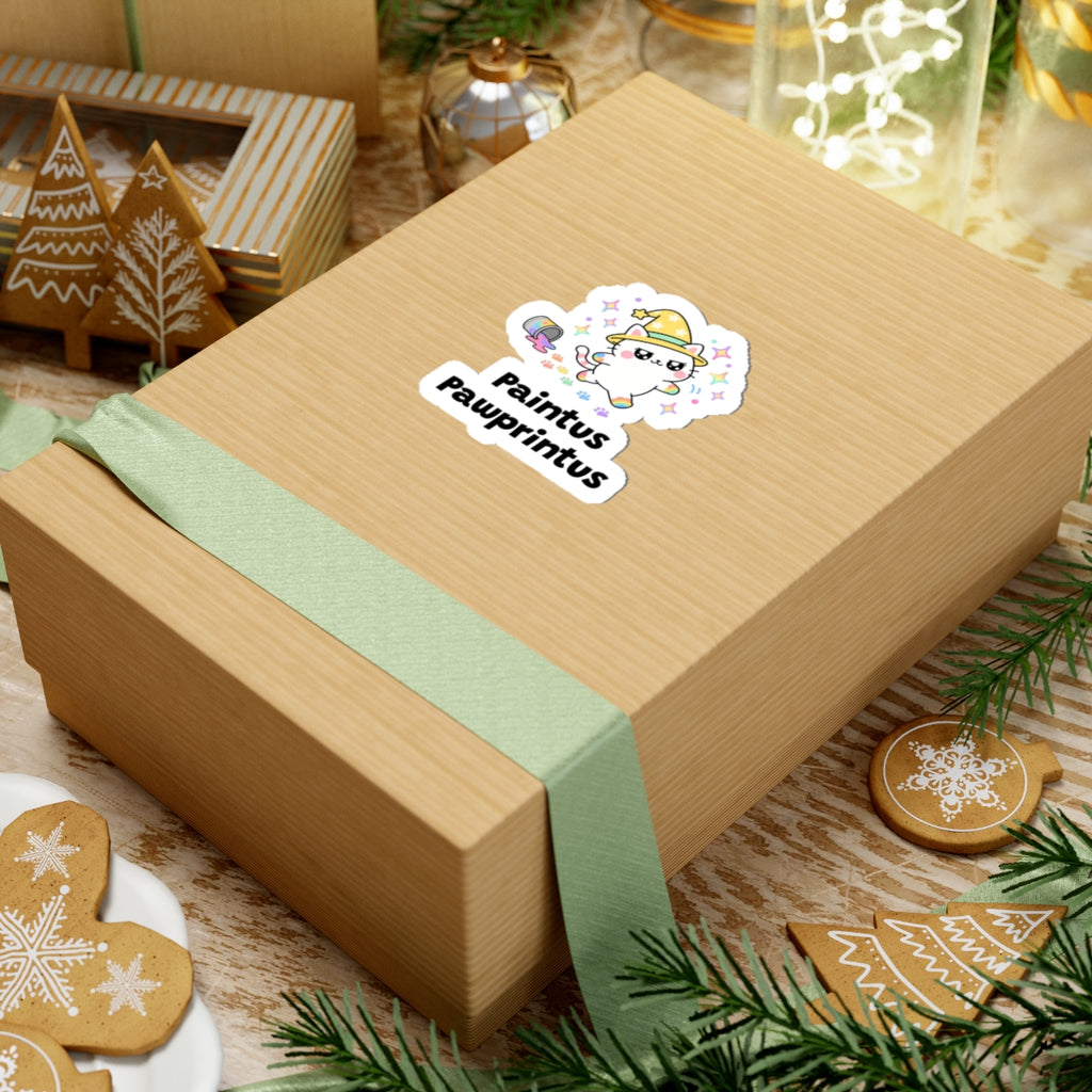 Paintus Pawprintus wizard cat sticker on a kraft gift box with a green ribbon and holiday cookies