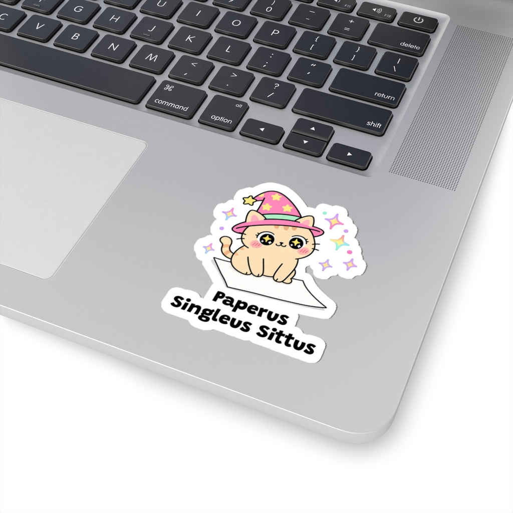 Paperus Singleus Sittus wizard cat sticker stuck on a silver laptop next to the keyboard