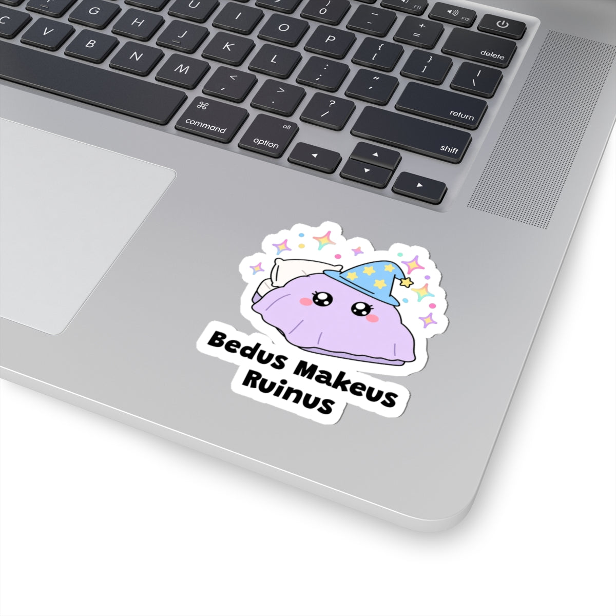 Bedus Makeus Ruinus wizard cat sticker stuck on a silver laptop next to the keyboard