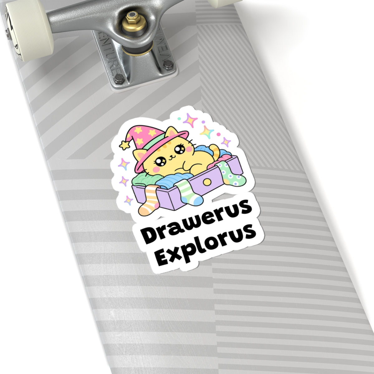 Drawerus Explorus wizard cat sticker on a grey skateboard deck near the truck