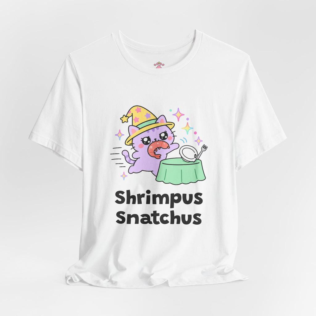 White Shrimpus Snatchus wizard cat T-shirt shown in a soft studio setting: lilac wizard cat in a yellow hat dashing off with a shrimp from a plate on a green table