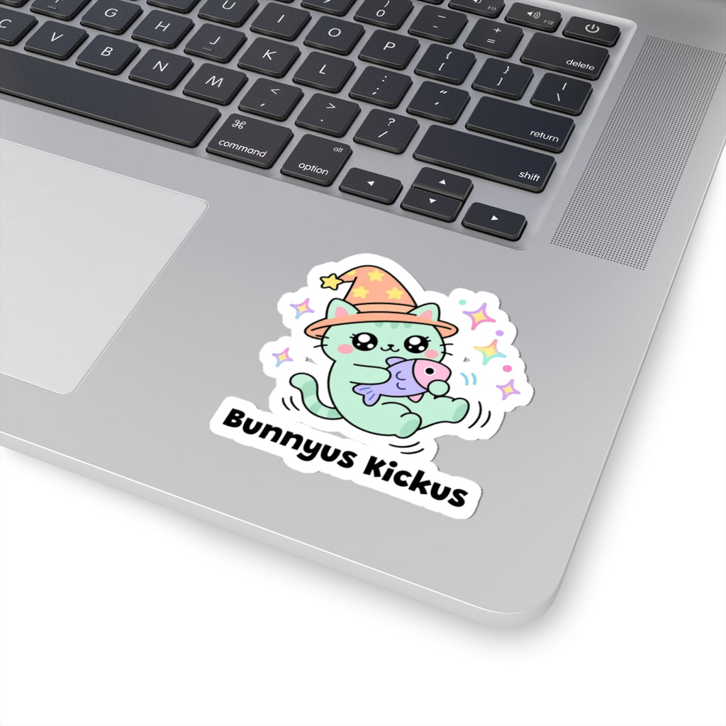 Bunnyus Kickus wizard cat sticker stuck on a silver laptop next to the keyboard