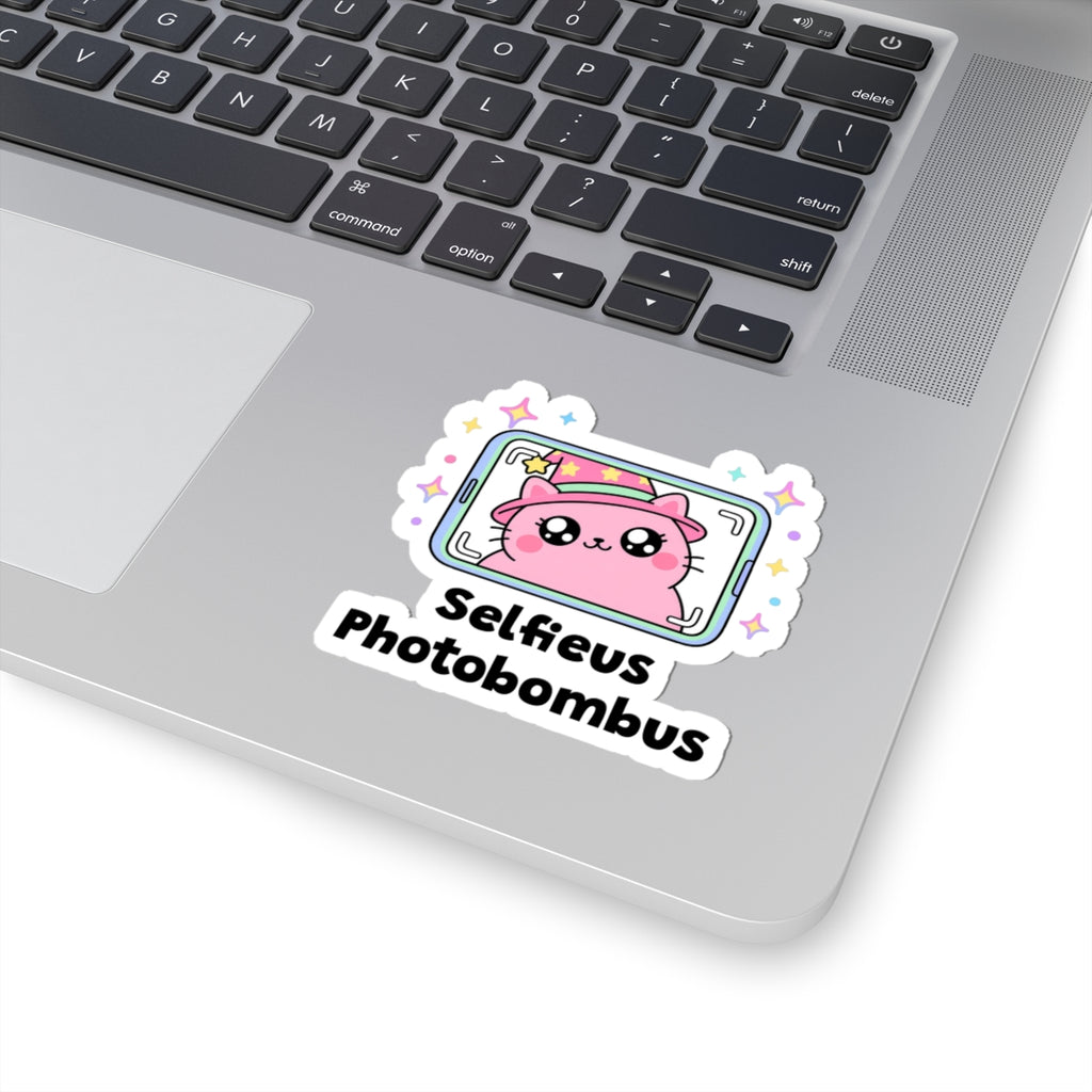 Selfieus Photobombus wizard cat sticker stuck on a silver laptop next to the keyboard