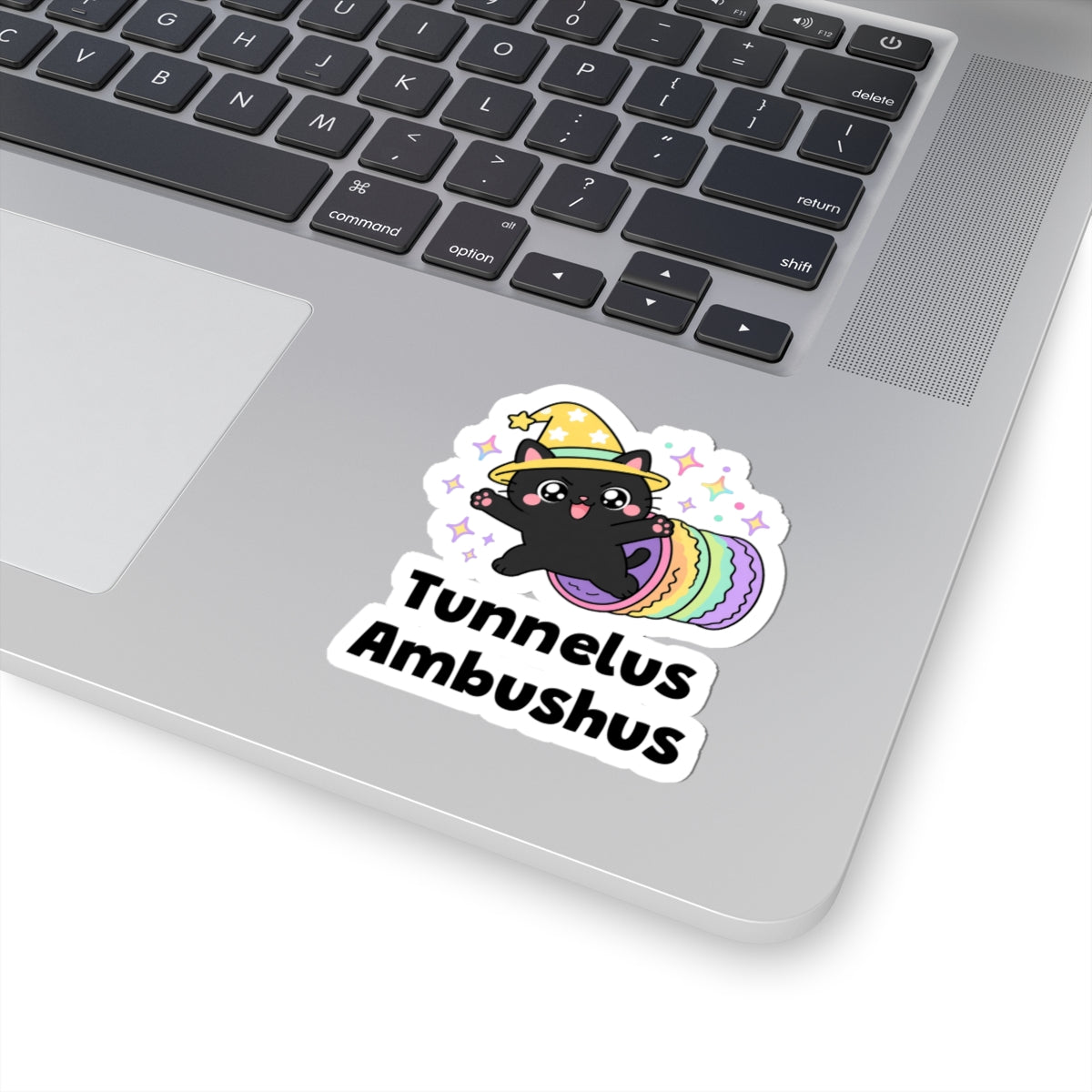 Tunnelus Ambushus wizard cat sticker stuck on a silver laptop next to the keyboard