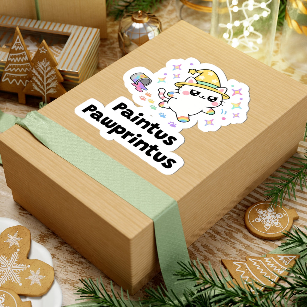 Paintus Pawprintus wizard cat sticker on a kraft gift box with a green ribbon and holiday cookies