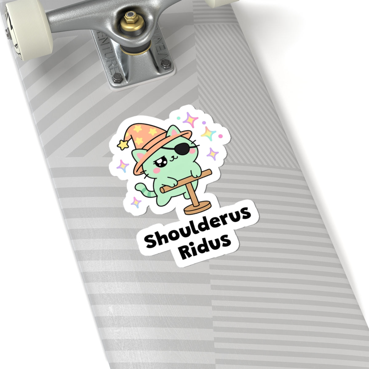 Shoulderus Ridus wizard cat sticker on a grey skateboard deck near the truck