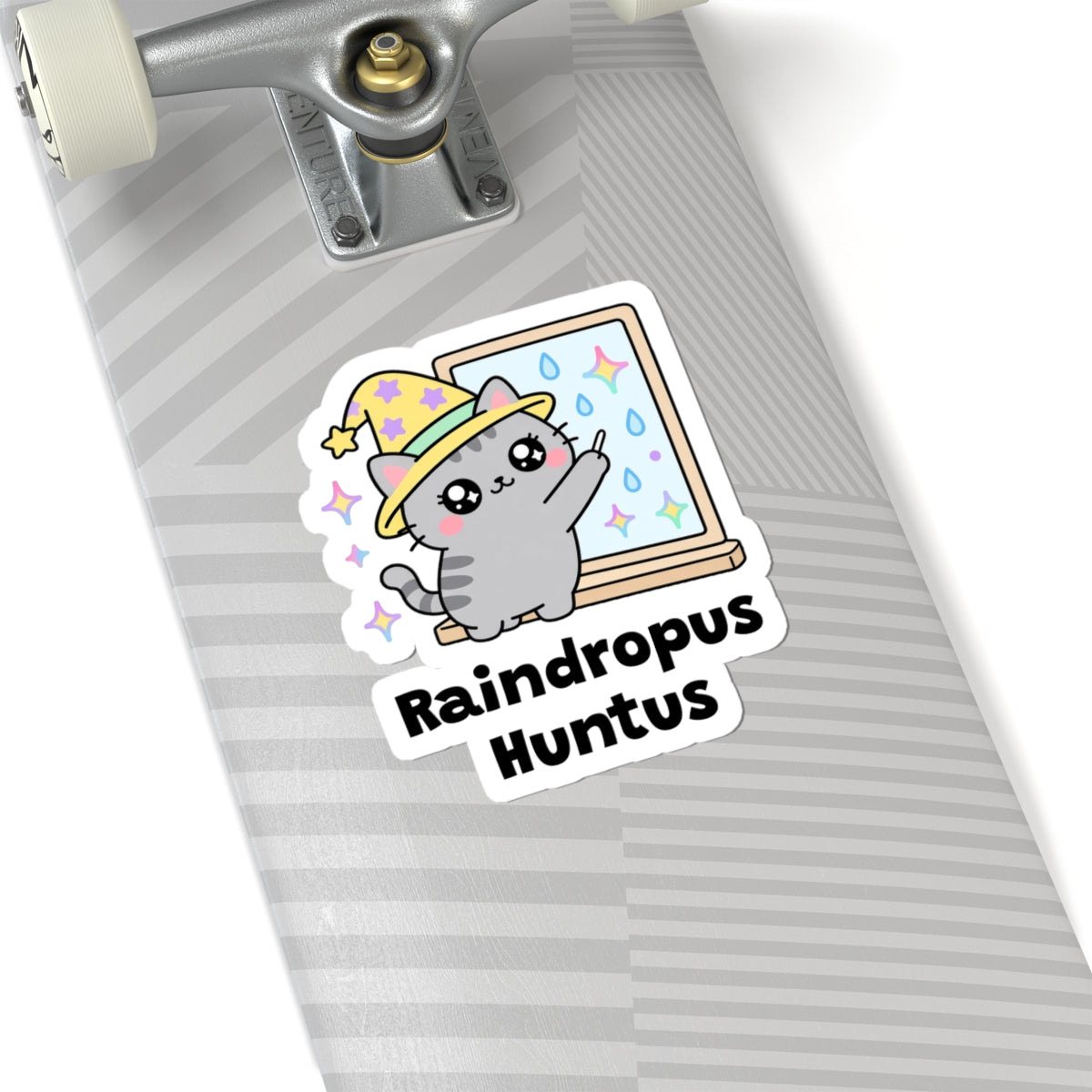 Raindropus Huntus wizard cat sticker on a grey skateboard deck near the truck