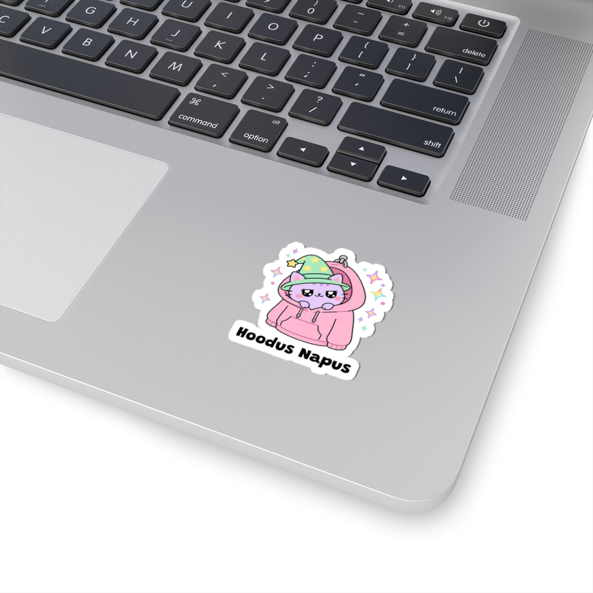 Hoodus Napus wizard cat sticker stuck on a silver laptop next to the keyboard