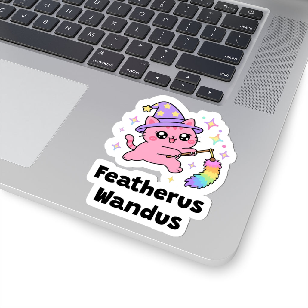 Featherus Wandus wizard cat sticker stuck on a silver laptop next to the keyboard