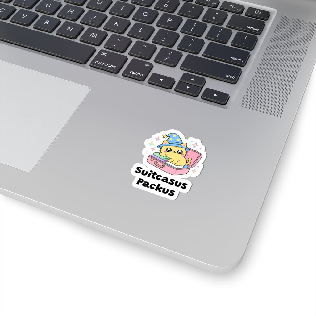Suitcasus Packus wizard cat sticker stuck on a silver laptop next to the keyboard