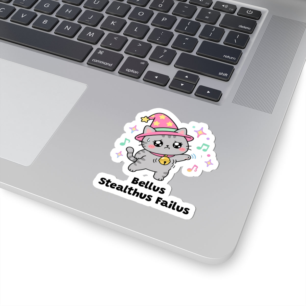 Bellus Stealthus Failus wizard cat sticker stuck on a silver laptop next to the keyboard