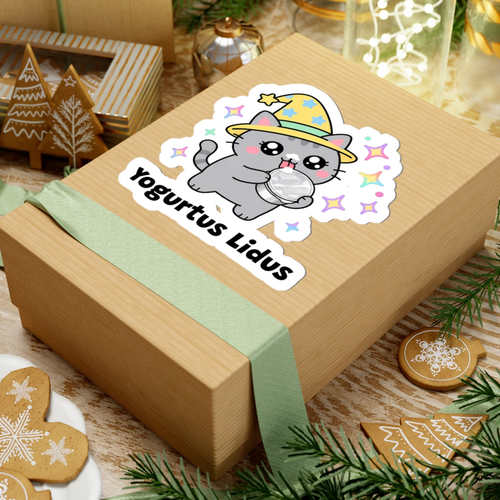 Yogurtus Lidus wizard cat sticker on a kraft gift box with a green ribbon and holiday cookies