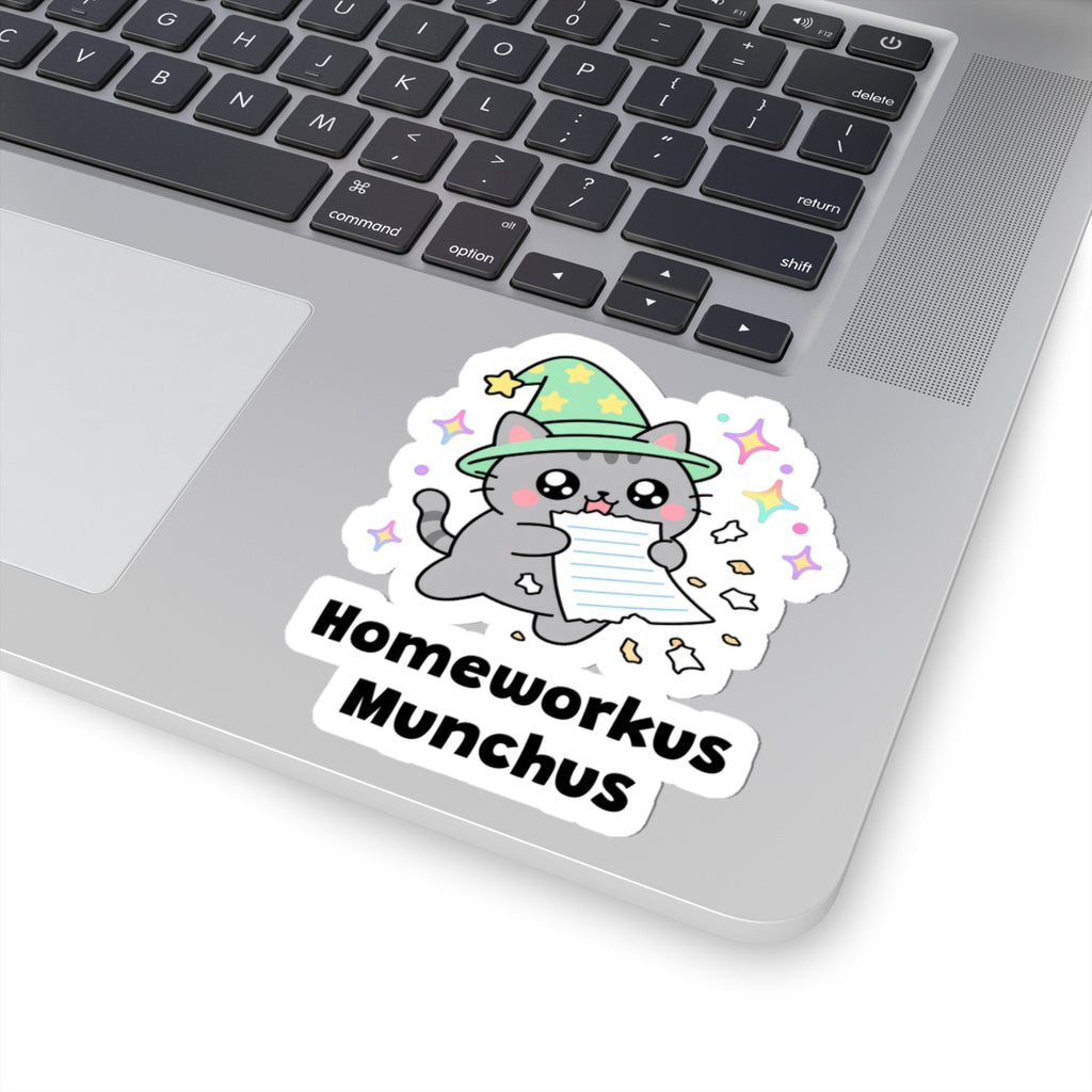 Homeworkus Munchus wizard cat sticker stuck on a silver laptop next to the keyboard