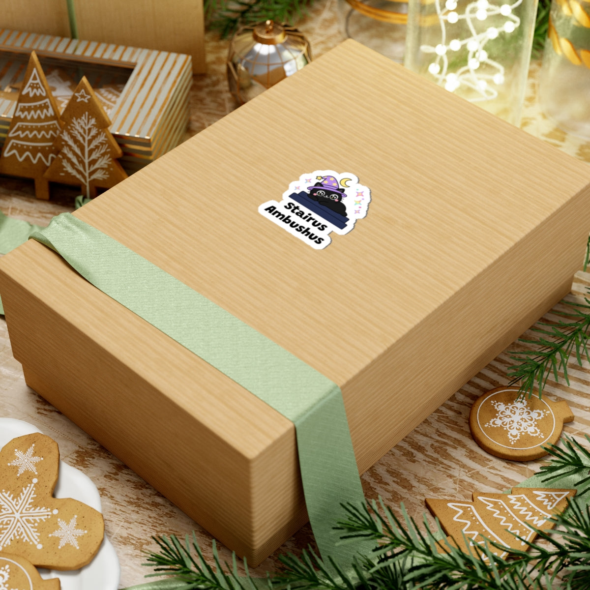 Stairus Ambushus wizard cat sticker on a kraft gift box with a green ribbon and holiday cookies