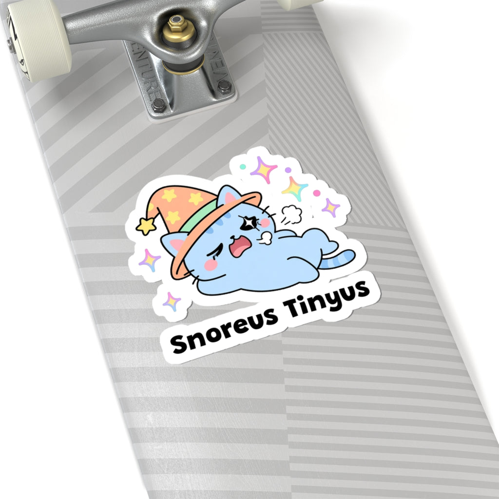 Snoreus Tinyus wizard cat sticker on a grey skateboard deck near the truck