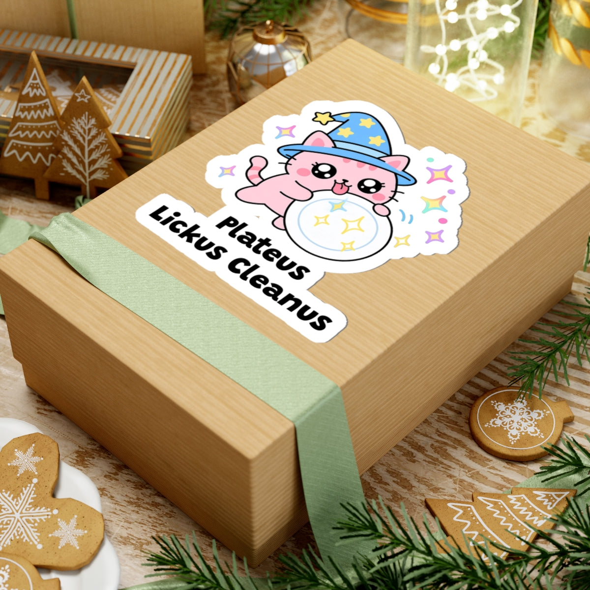 Plateus Lickus Cleanus wizard cat sticker on a kraft gift box with a green ribbon and holiday cookies